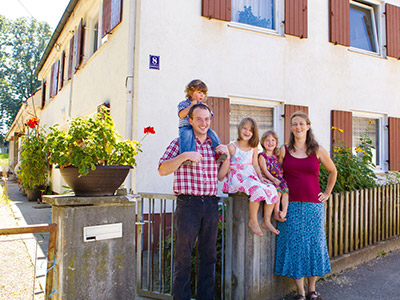 © Feneberg/Bio mit Gesicht Familie vor Haus