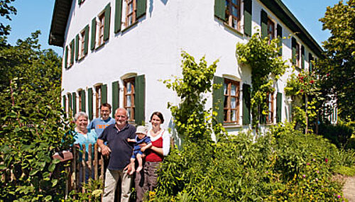 Betriebsleiterfamilie vor Bauernhaus